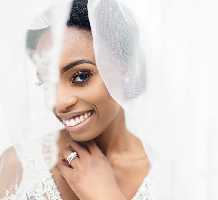 Bride smiles at the camera wearing her veil