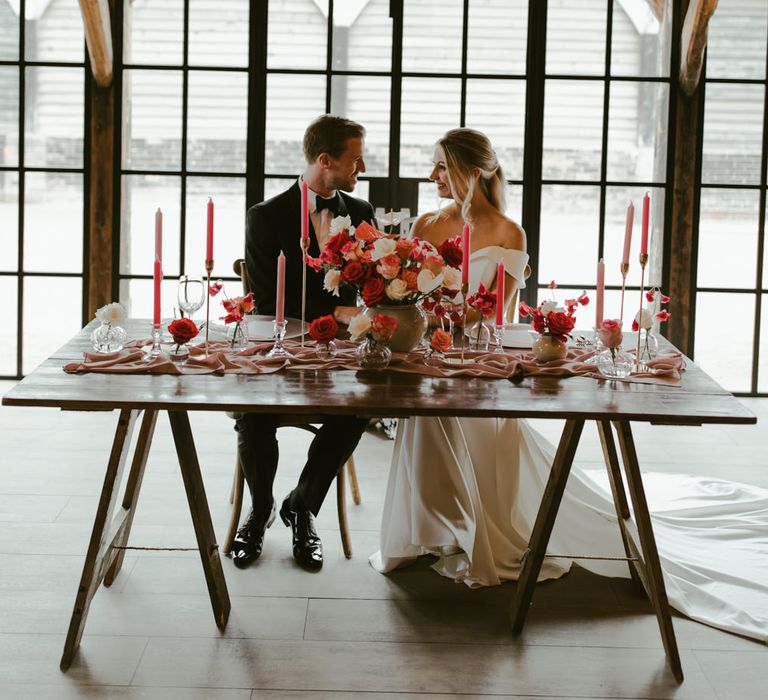 Bride & groom sit within industrial barn