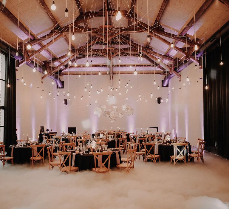 The floor around the wedding tables is covered in a layer of smoke from a smoke machine, creating a heavenly atmosphere