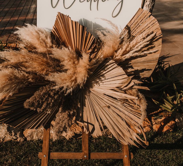 Wedding welcome sign with dried palm leaves and pampas grass