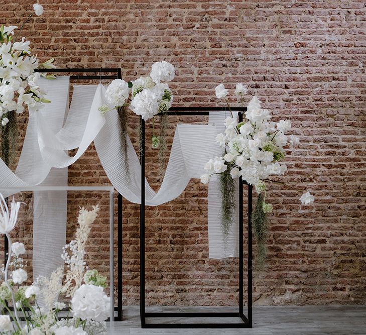 Ceremony altar wedding decor with black frames, white flowers and drapes 