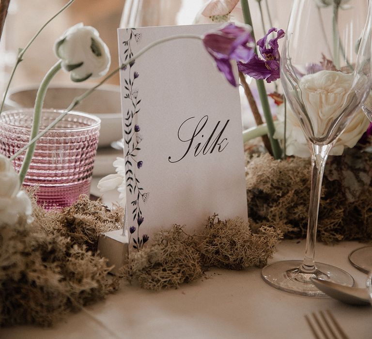 Floral centrepiece flowers with moss and purple alliums 