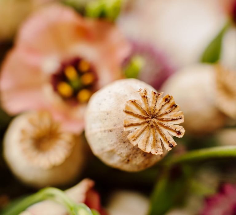 Dried poppy heads, pink wild roses and dahlias for table centrepieces at Italian elopement