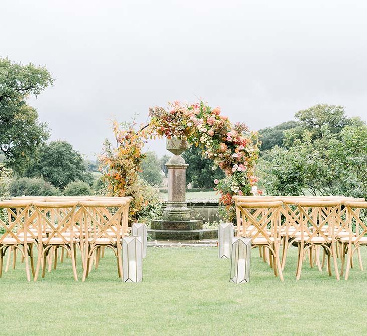 Outdoor wedding ceremony flowers with autumn moon gate decor 