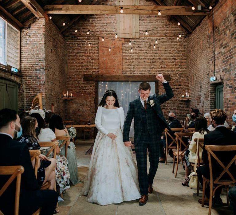 Bride and groom descending down the aisle at East Yorkshire Barns wedding venue