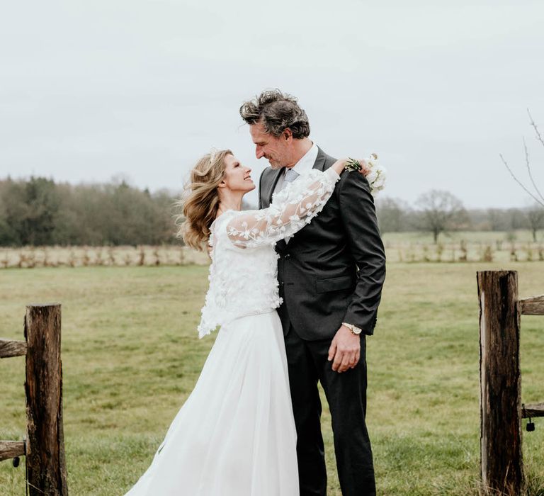 Bride and groom in the fields of rustic luxe wedding venue High Billinghurst Farm