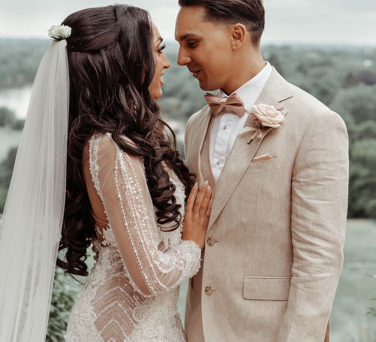 Bride & groom look lovingly at one another outdoors on their wedding day after first look moment