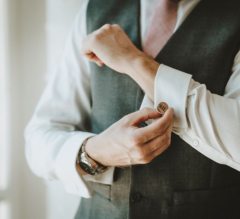 Groom does up his cufflinks on his wedding day