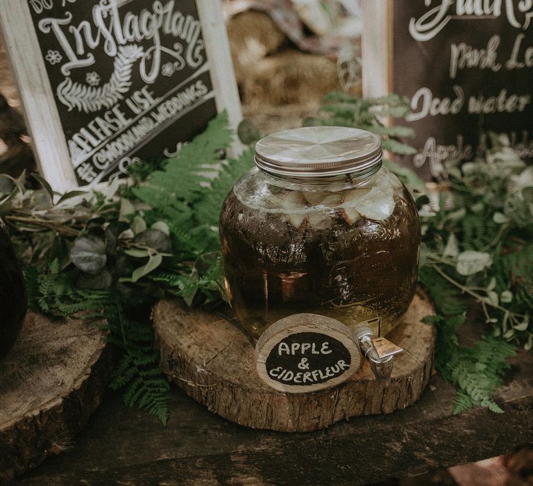 Mason jars for drinks set upon wooden pedestals complete with chalkboard signs 