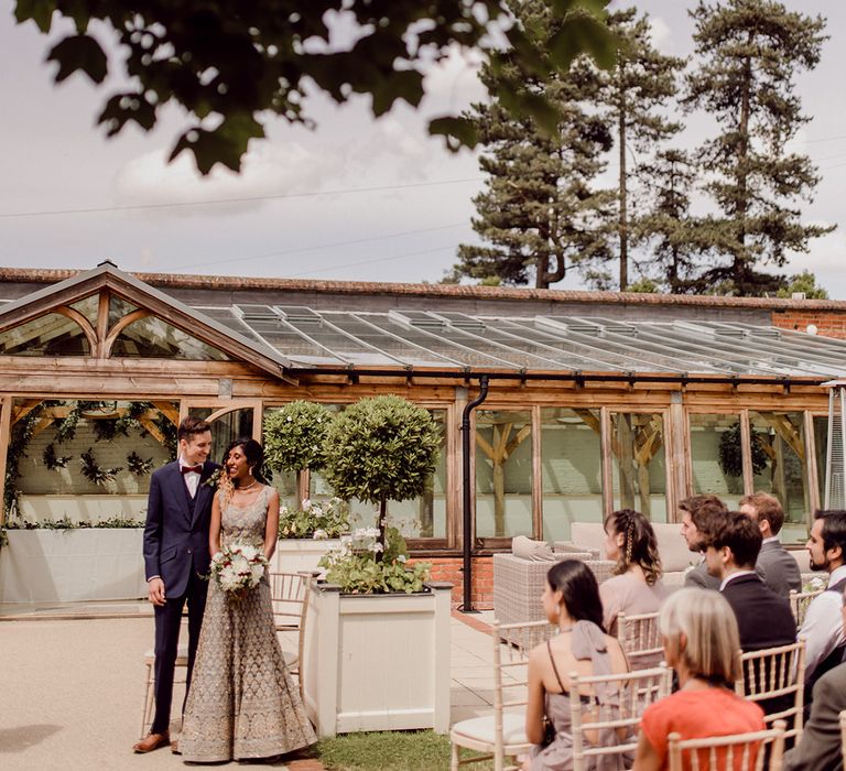 Bride & groom stand with one another at the front of the aisle on their wedding day | Joshua Gooding Photography