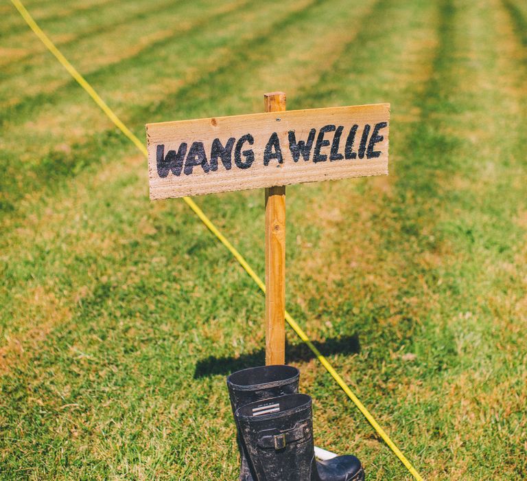 Wang A Wellie sign on manicured lawn for outdoor wedding games | Story + Colour