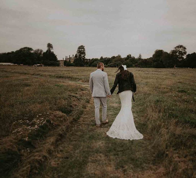 Bride in leather jacket cover up over her lace wedding dress