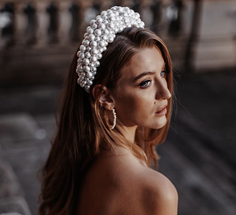 Bride in a strapless wedding dress with bow back and pearl headband 