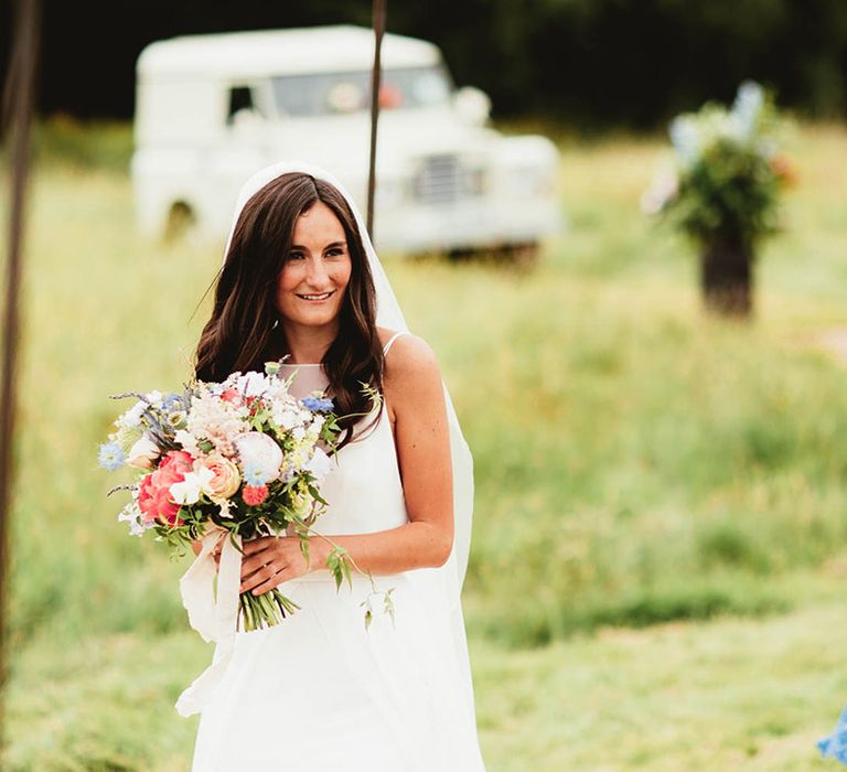 Bride carries floral bouquet