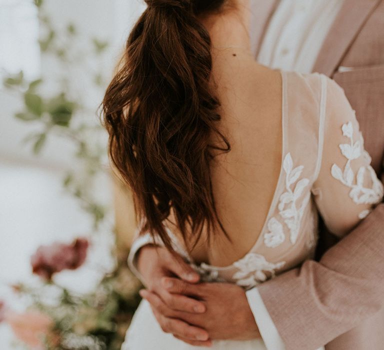 Wedding hairstyle with bride with loose curls tied back in a ponytail 