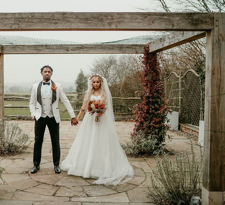 Bride and groom hold hands at golf club wedding