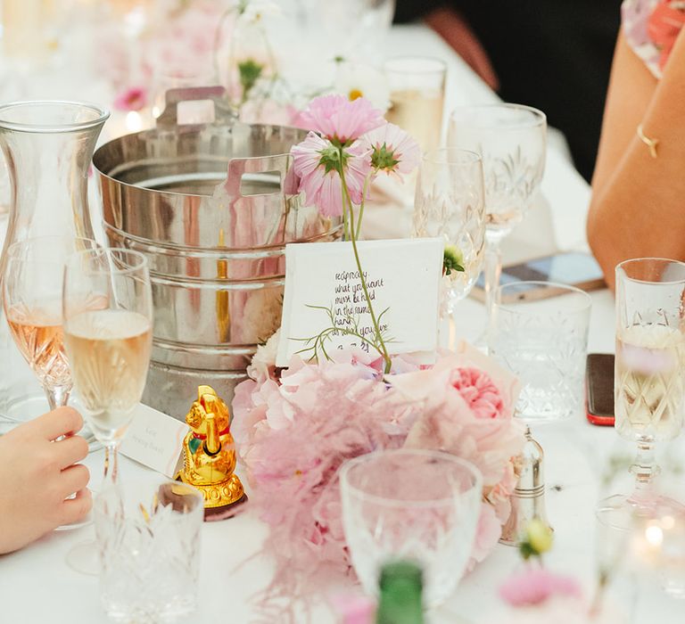 Pretty and pastel pink wedding flower arrangements for table settings with hand-written signs 