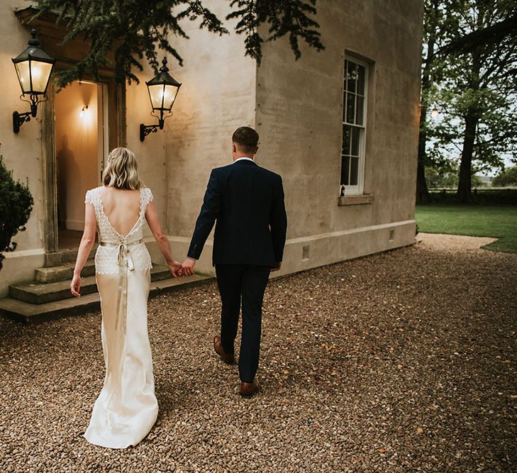 Bride & groom walk with one another outdoors for Spring wedding 