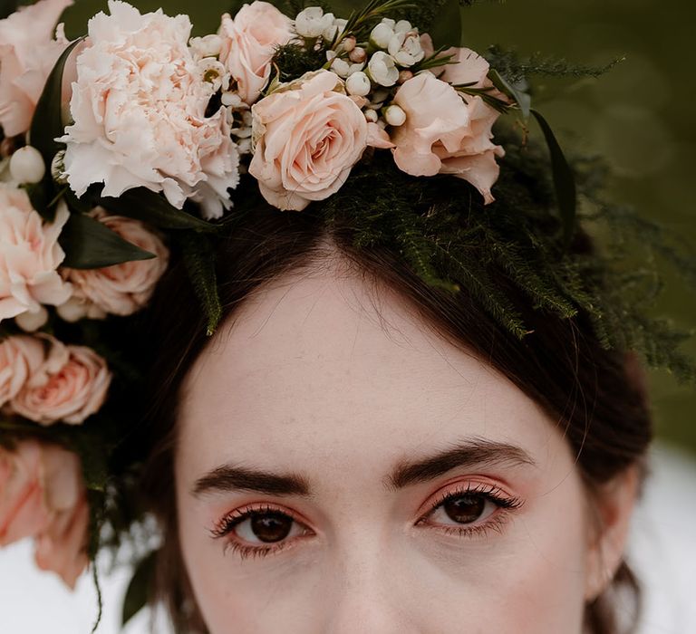 Bride with a pinned up do and flower crown with blush eyeshadow and lipstick