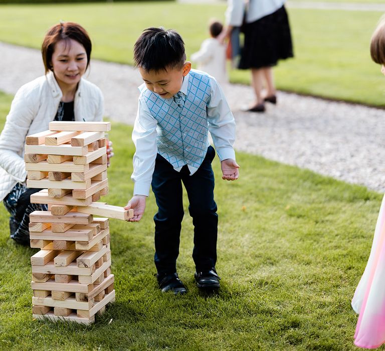 Children play giant Jenga on the lawn 