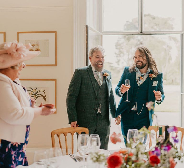 Grooms laugh during personal wedding speeches for intimate reception at Kew Gardens 