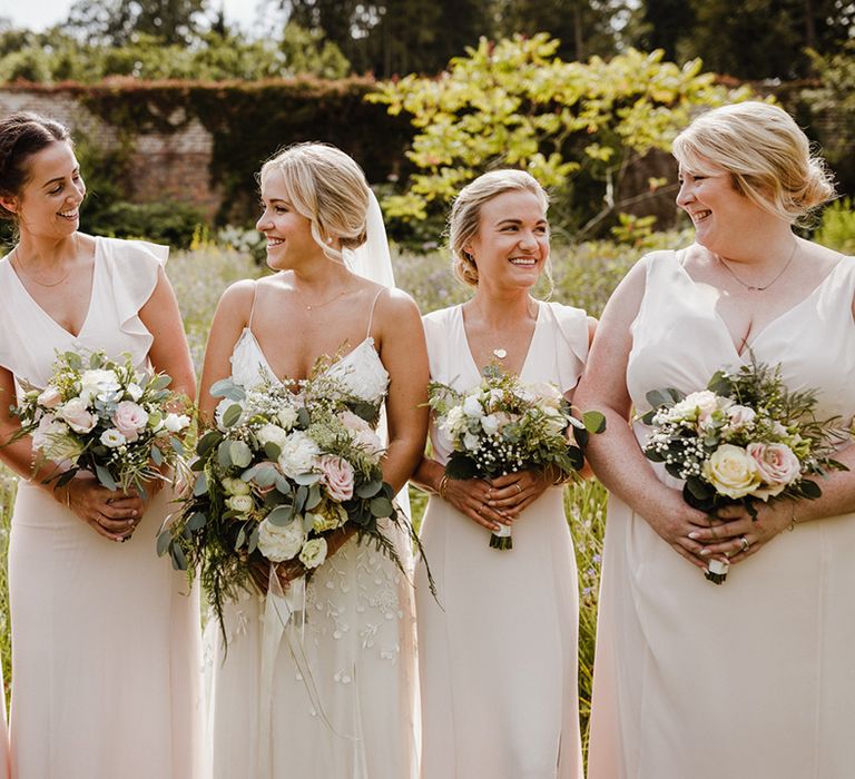 White bridesmaid dresses worn by the bridal party with the bride in a applique wedding dress for classic wedding 