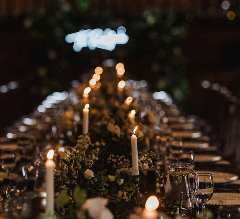 Botanical rustic wedding tablescape with white pillar candles, foliage table runners, white garden rose, hydrangea and cows parsley centrepieces and white wedding napkins 