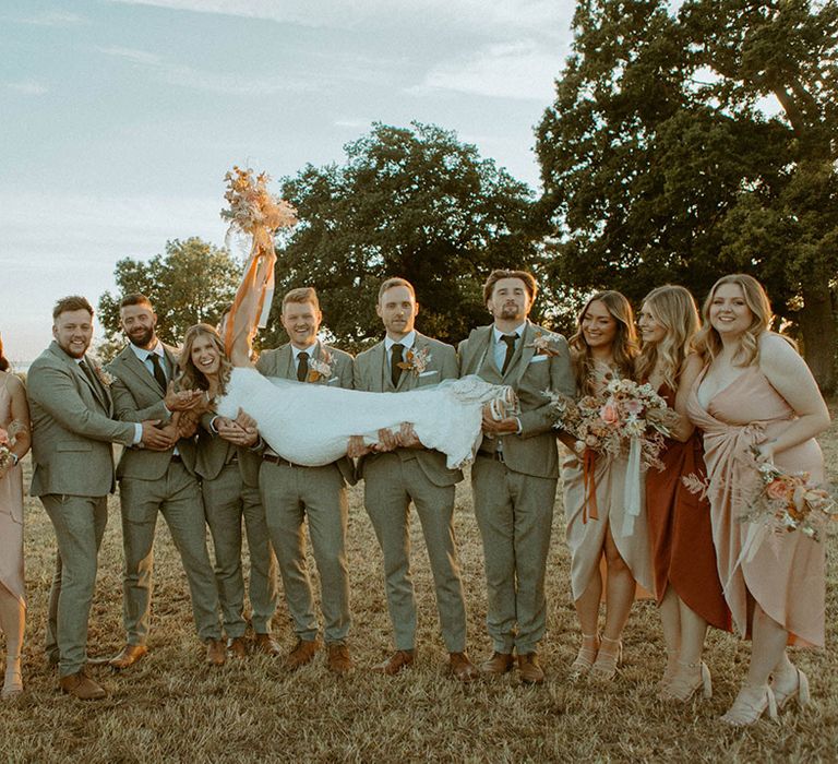 The bride, groom, bridesmaids, and groomsmen posing for wedding party photo at boho wedding 