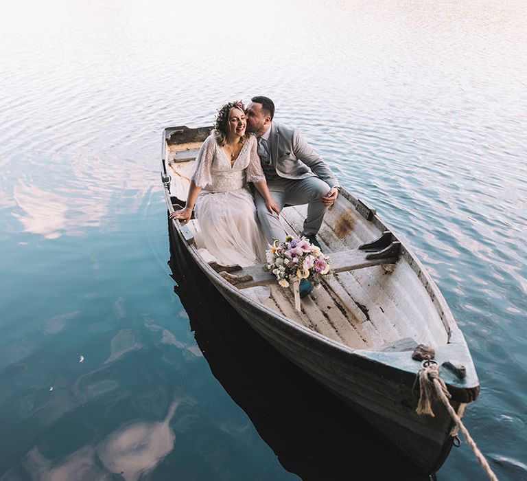 Bride and groom riding in a wooden boat at Wyresdale Park Lancashire wedding venue 