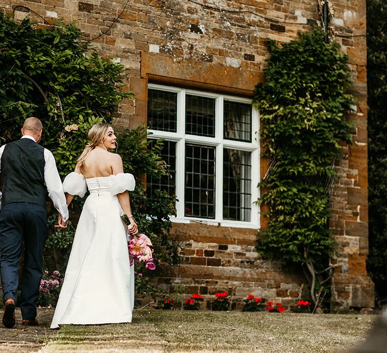 Bride in strapless wedding dress with Jesus Peiro puff sleeves with groom in navy suit 