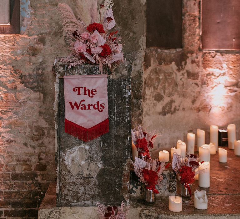 Pink and red retro wedding banner sign with dried wedding flowers and pampas grass at the Asylum Chapel 