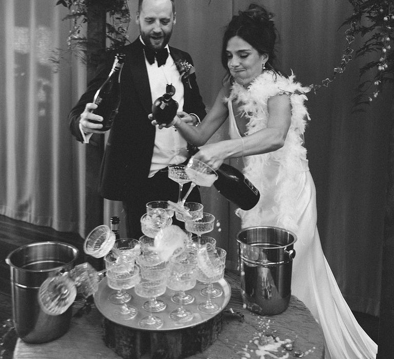 Champagne tower fail for the bride and groom who topple the tower over as they pour the champagne 