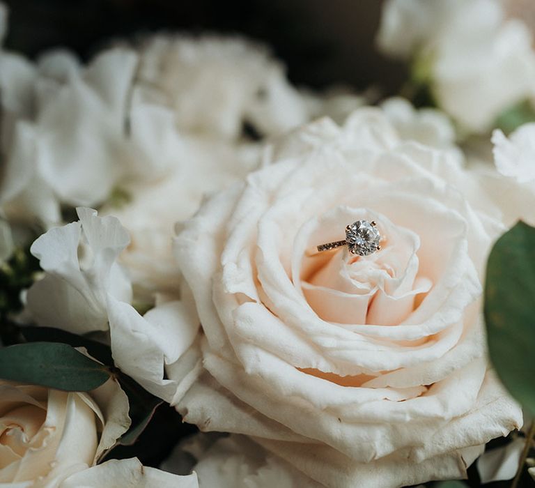 White rose wedding flowers with diamond engagement ring 