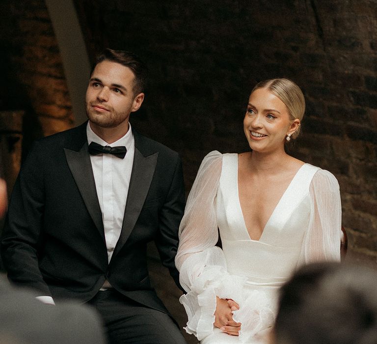 The bride and groom sit at their wedding ceremony together 