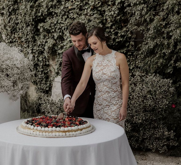 Italian wedding cake being cut by the bride and groom 