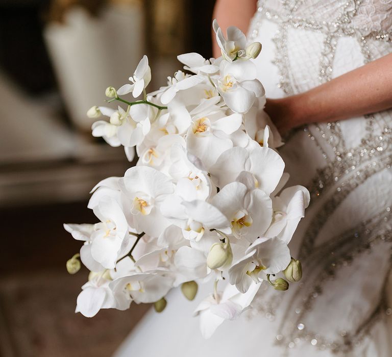 Bride carrying white orchid wedding bouquet 