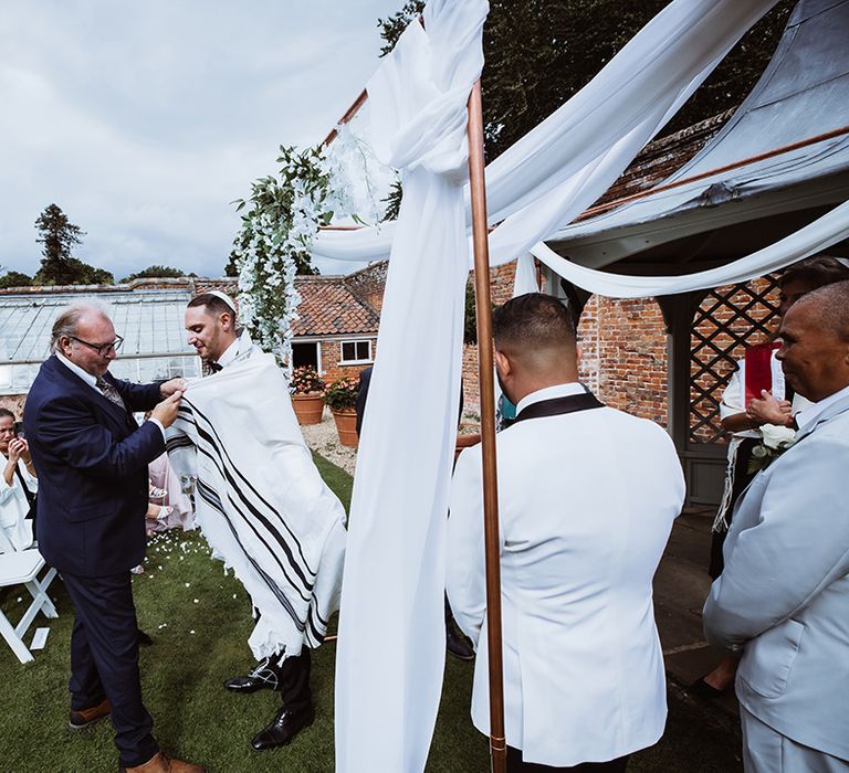 Jewish wedding ceremony with white chuppah at outdoor wedding venue space