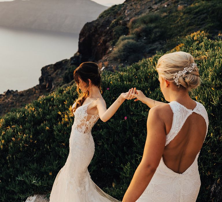 Bride leading bride down the stairs at destination wedding in Santorini 