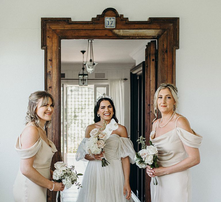 Bridal party wearing champagne neutral toned bridesmaid dresses with the bride 