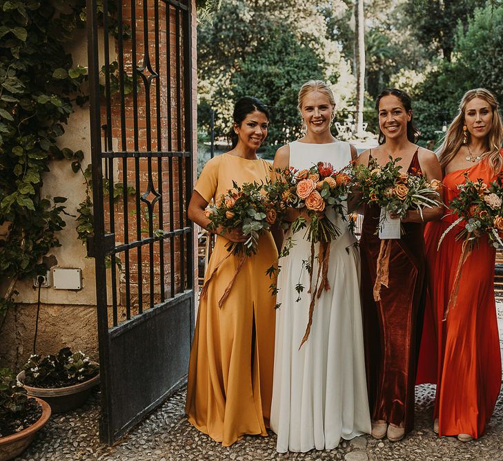 Bridesmaids in mustard, rust and orange dresses for earthy Andalusia wedding 