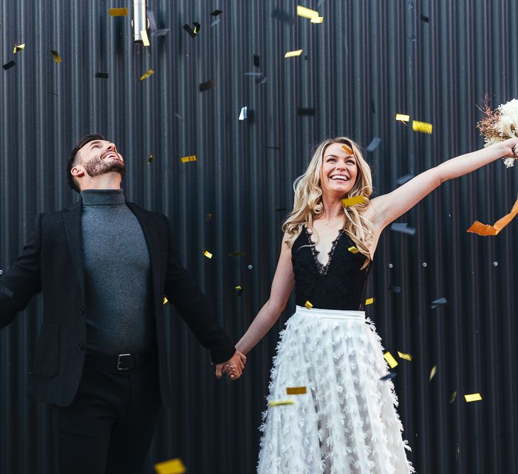 Gold confetti moment with groom in turtleneck and blazer