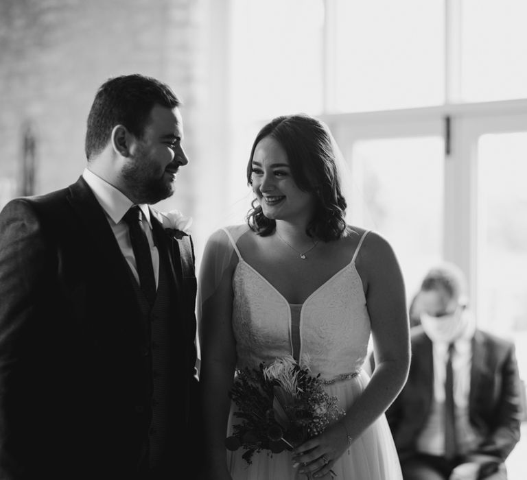 Smiling bride and groom at the altar