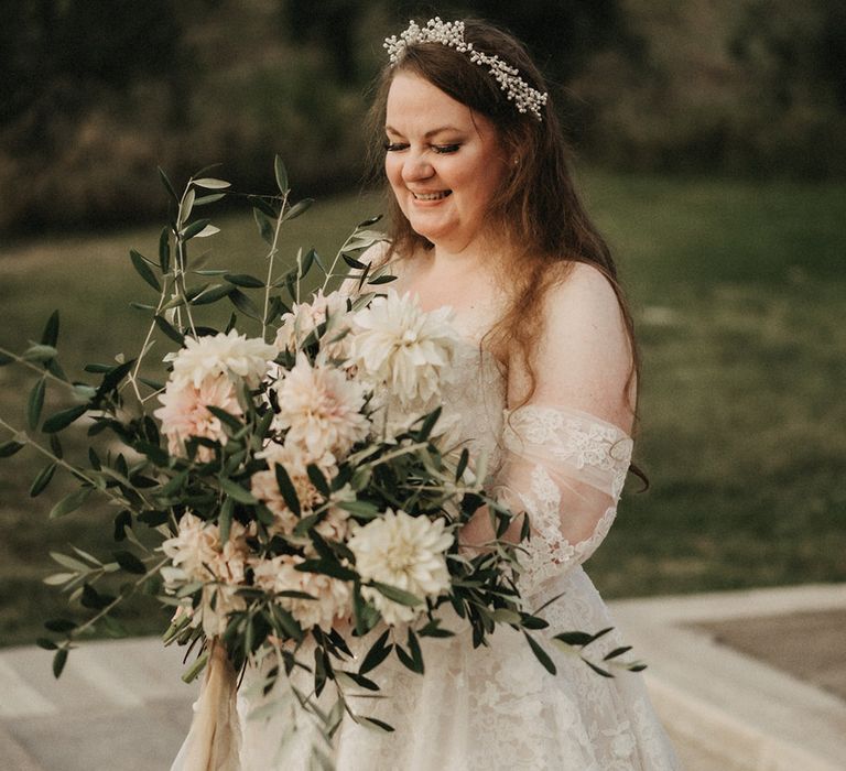 Saskia smiling with her bridal olive bouquet