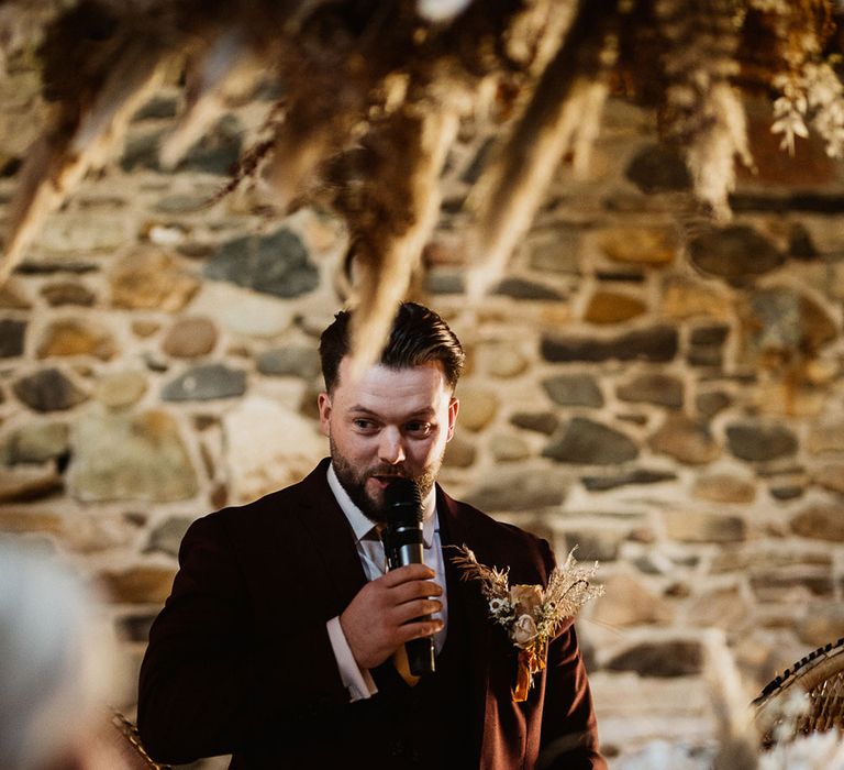 Groom in burgundy Marc Darcy suit makes speech at small wedding in the Lake District