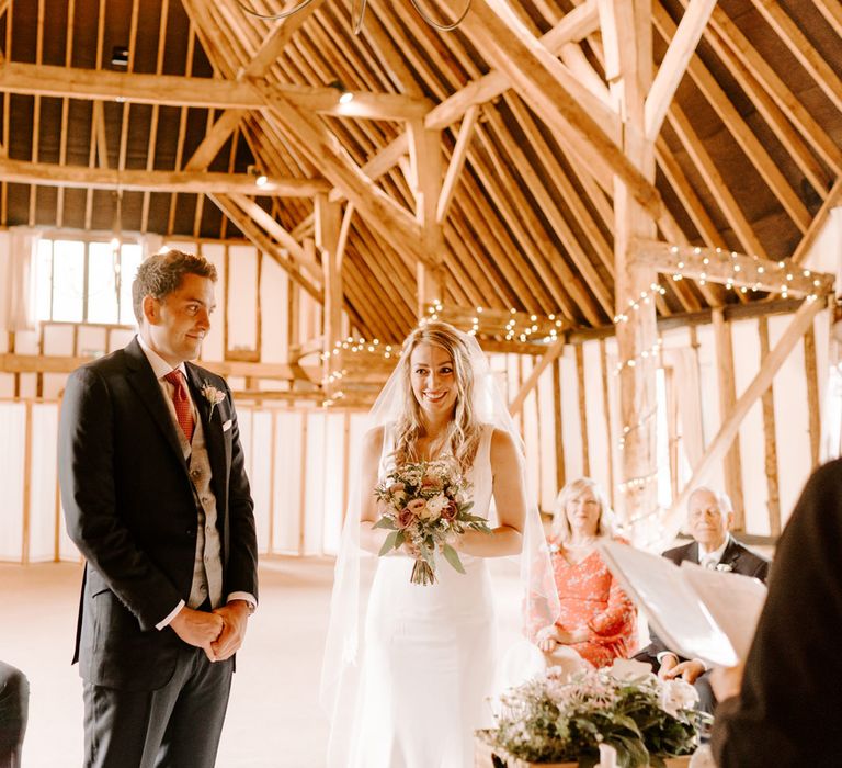 Bride and groom exchanging vows at Clock Barn wedding