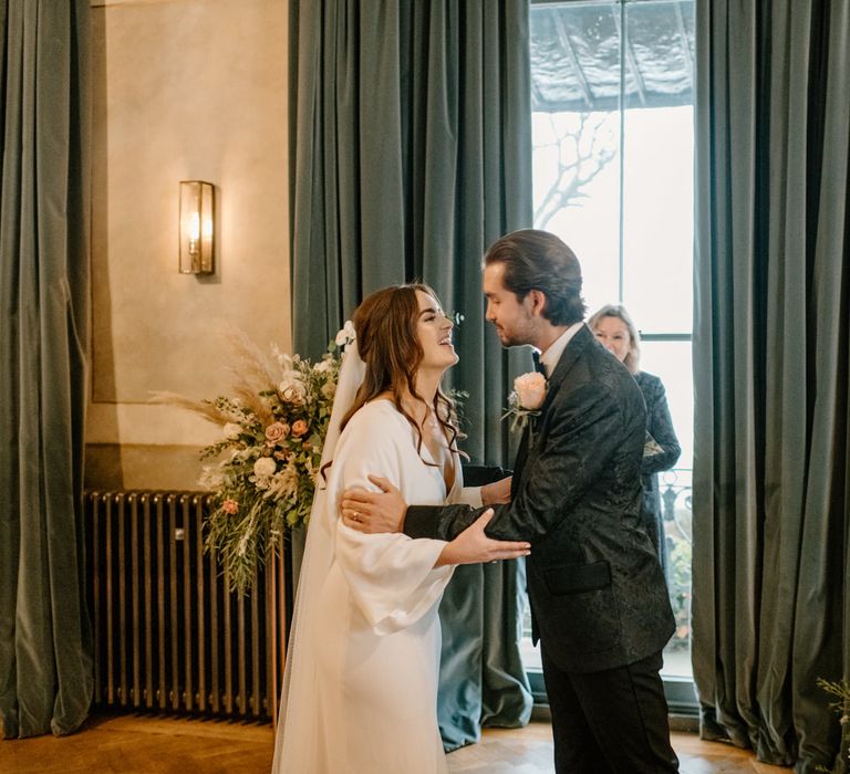 Bride and groom holding each other at wedding ceremony 