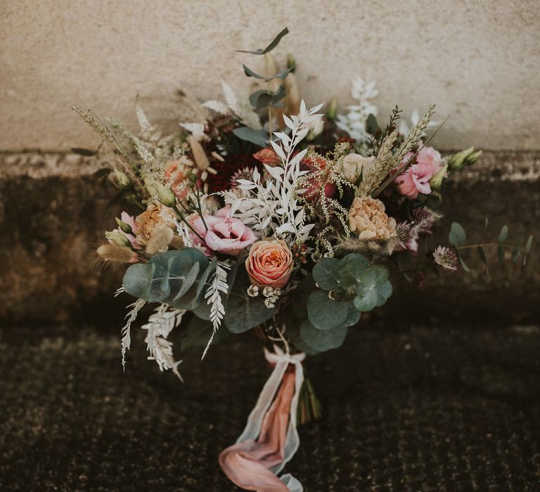 Pastel bouquet featuring green foliage tied with pink satin ribbon 