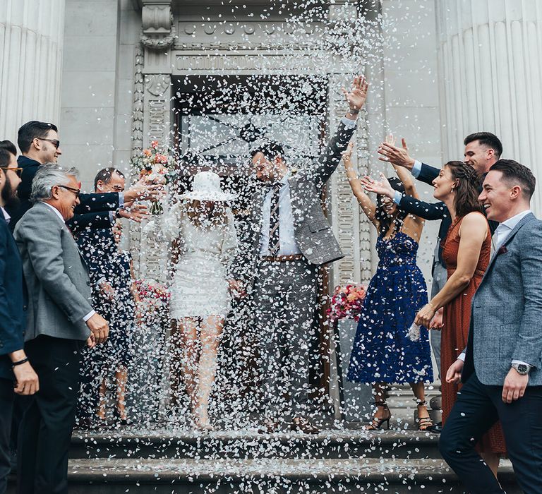 Confetti moment at Marylebone townhall wedding with short net a porter wedding dress 