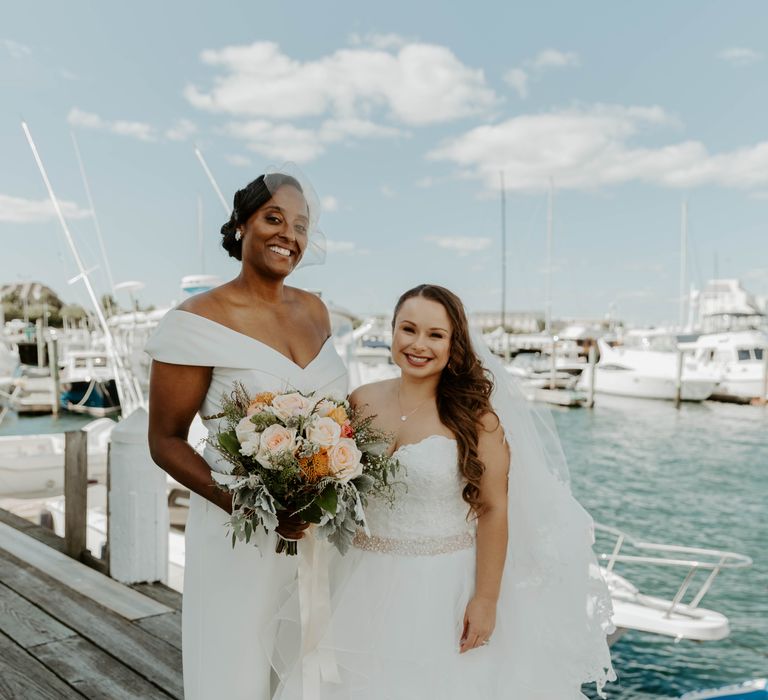 Same sex couple standing on the docks at their Regatta Place, Newport wedding on Rhode Island 