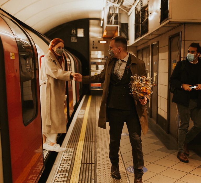 Bride and groom stepping off London underground tube